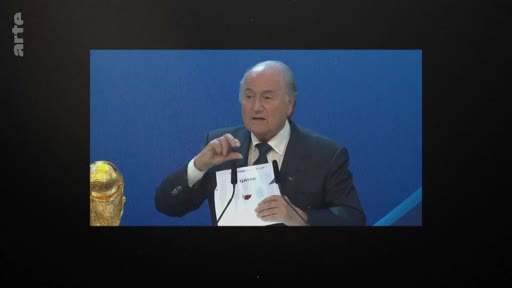 L'ancien président de la FIFA Sepp Blatter s'exprime lors d'une conférence de presse, avec le trophée de la Coupe du monde visible à ses côtés.