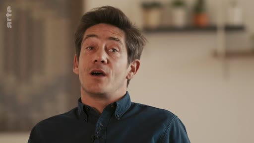 Un homme s'exprime face caméra dans un cadre intérieur, lors d'une interview diffusée sur la chaîne Arte.