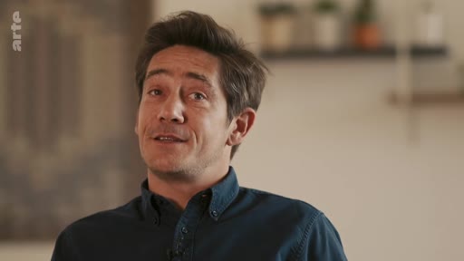 Un homme s'exprime face caméra lors d'une interview télévisée, probablement pour un documentaire ou un reportage diffusé sur la chaîne Arte.