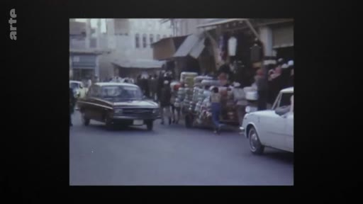 Vue d'archive montrant une rue animée avec des voitures et des passants au Qatar en 1971, à l'époque de l'indépendance du pays.