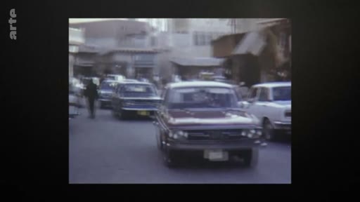 Des voitures circulent dans une rue du Qatar en 1971, illustrant le développement urbain et la circulation automobile au moment de l'indépendance du pays.