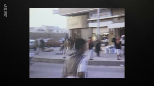 Vue d'archive montrant une rue commerçante au Qatar en 1971, peu après l'indépendance du pays. On y voit des passants et des véhicules dans un environnement urbain typique de cette époque.