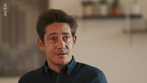 Un homme est filmé en gros plan lors d'une interview pour le documentaire La révolution de palais de 1995.