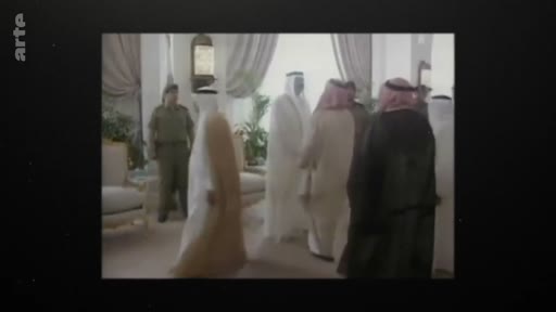 Des dignitaires arabes, dont certains portent la thobe et le ghutra, sont réunis dans un salon officiel lors d'une rencontre diplomatique. La scène, filmée en archives, montre un échange formel dans un intérieur luxueux.