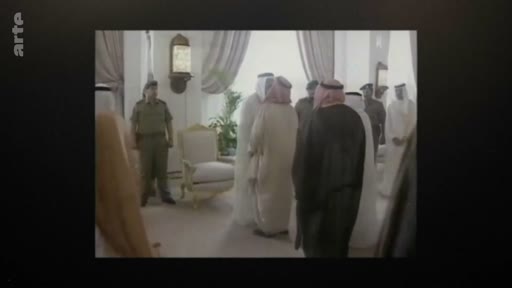 Des hommes en tenue traditionnelle arabe, dont certains portent des keffiehs, sont réunis dans un salon officiel lors d'une rencontre diplomatique. Un officier en uniforme militaire est également présent dans la pièce.