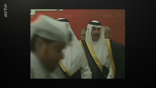 Des officiels portant la tenue traditionnelle arabe, incluant le keffieh et le bisht, lors d'une cérémonie ou d'un événement officiel. L'image semble provenir d'archives télévisées.