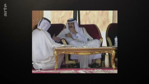 L'ancien émir du Qatar, Hamad bin Khalifa Al Thani, est assis sur un fauteuil lors d'une rencontre officielle en extérieur, portant la tenue traditionnelle qatarienne.
