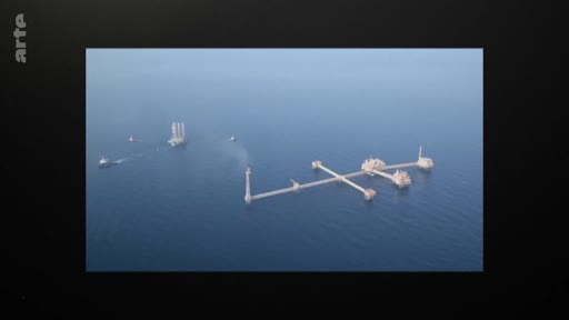 Vue aérienne d'une installation pétrolière offshore en pleine mer, avec des navires de soutien à proximité, illustrant les activités d'extraction d'hydrocarbures.