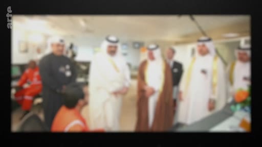 Plusieurs hommes en tenue traditionnelle, dont certains portent des thobes et des ghutras, lors d'une visite officielle ou d'une rencontre diplomatique dans un environnement intérieur.