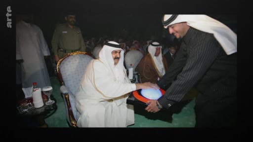 L'émir du Qatar, Tamim ben Hamad Al Thani, est photographié lors d'un événement officiel, interagissant avec un objet technologique ou symbolique. Cette image d'archive montre le dirigeant qatari dans un contexte protocolaire.