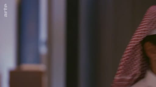 Un homme portant une coiffe traditionnelle, la ghutra, est filmé en gros plan dans ce qui semble être une séquence d'archive ou un reportage sur le Moyen-Orient.