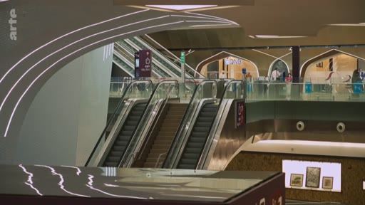 Vue intérieure d'une station de métro moderne, probablement à Doha, caractérisée par une architecture contemporaine avec des arches et des escaliers mécaniques. L'image montre l'aménagement intérieur d'une infrastructure de transport public haut de gamme.
