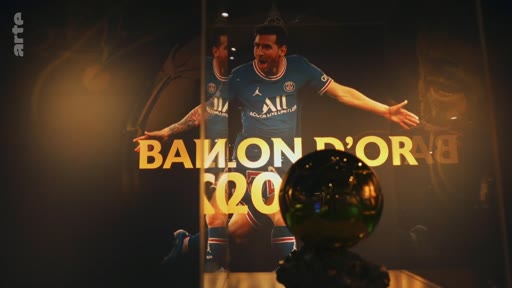 Le trophée du Ballon d'Or est présenté dans une vitrine devant une photographie de Lionel Messi portant le maillot du Paris Saint-Germain. Cette image illustre le prestige du prix individuel le plus convoité du football mondial.