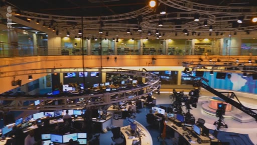 Vue d'ensemble de la rédaction et du plateau de télévision de la chaîne Arte, montrant les journalistes au travail devant leurs écrans et les installations techniques.