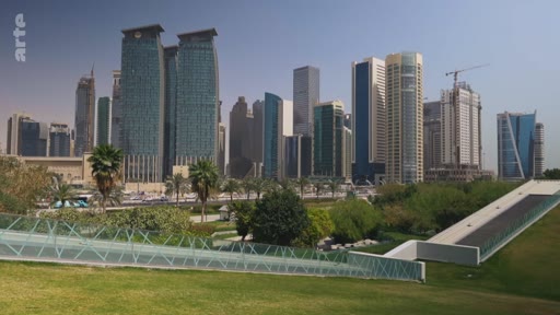 Vue d'ensemble du quartier d'affaires de Doha, au Qatar, avec ses gratte-ciel modernes et ses espaces verts au premier plan. Le paysage urbain illustre le développement économique et architectural de la capitale qatarienne.