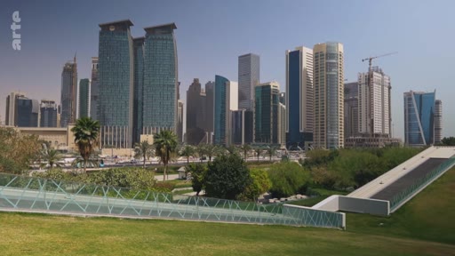 Vue d'ensemble du quartier d'affaires de Doha, au Qatar, avec ses gratte-ciel modernes et ses espaces verts au premier plan. Cette image illustre le développement urbain et l'architecture contemporaine de la capitale qatarienne.