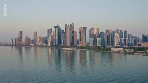 Vue panoramique de la skyline de Doha au Qatar, montrant les gratte-ciels modernes le long de la corniche au coucher du soleil.