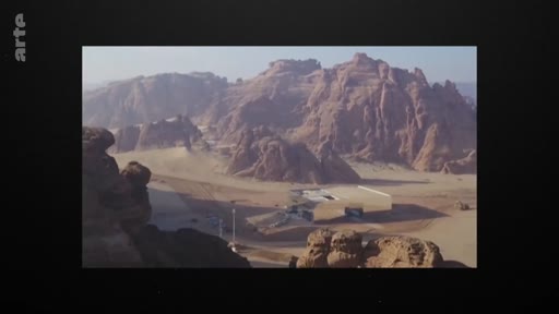 Vue panoramique du site archéologique d'Al-Ula en Arabie saoudite, mettant en évidence les formations rocheuses désertiques et les infrastructures modernes du site. Ce lieu historique est un centre majeur pour le tourisme culturel et les recherches archéologiques dans la région.