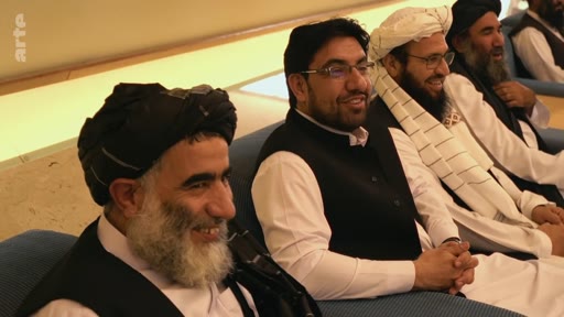 Plusieurs membres des Talibans, dont certains portent des turbans traditionnels, sont assis côte à côte lors d'une réunion officielle. La scène montre des responsables talibans dans un cadre formel, reflétant les dynamiques de pouvoir en Afghanistan.