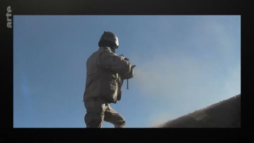 Un soldat équipé d'un casque et d'un gilet tactique est en action sur le terrain, tirant avec une arme à feu dans un environnement extérieur. L'image illustre des opérations militaires ou un entraînement au combat.
