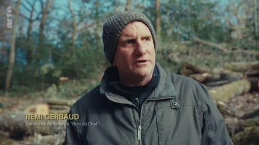 Rémi Gerbaud, membre du comité de défense du « Bois du Chat », est interviewé en extérieur dans une zone forestière. Il témoigne sur les enjeux liés à la gestion et à la préservation du « Bois du Chat ».