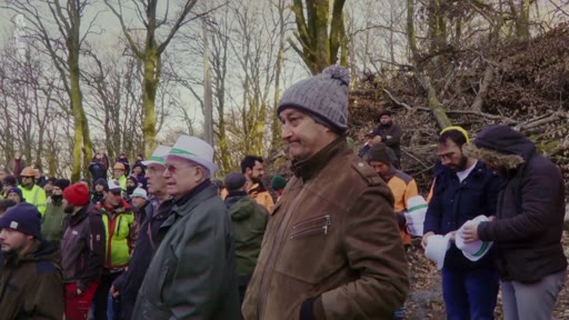 Un groupe de personnes, dont certaines portent des chapeaux blancs, est rassemblé dans une zone boisée lors d'un événement de la filière forestière. L'ambiance est celle d'une manifestation ou d'un rassemblement professionnel en extérieur.