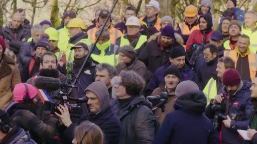 Une foule dense composée de professionnels, dont certains portent des casques de chantier, lors d'un rassemblement de la filière forêt-bois en extérieur. Des journalistes équipés de caméras et de micros sont présents pour couvrir l'événement.