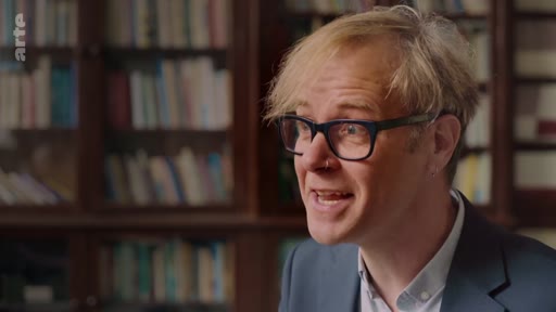 Un expert intervient lors d'une interview pour discuter des bénéfices et des processus de la régénération naturelle des forêts, avec une bibliothèque en arrière-plan.