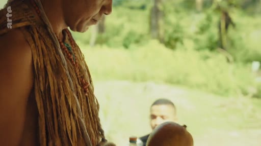 Un membre de la communauté autochtone Pataxó, vêtu d'ornements traditionnels, est filmé en gros plan lors d'une rencontre dans son territoire. Cette image illustre la culture et les traditions des peuples autochtones du Brésil.