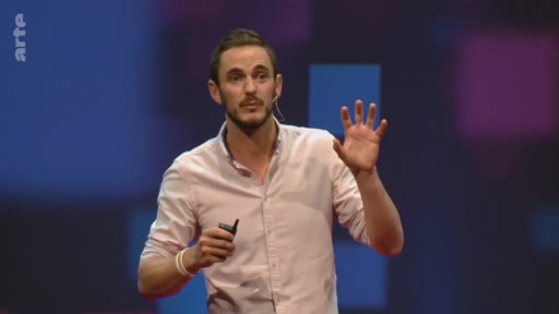 Un conférencier s'exprime sur scène lors d'une présentation sur le potentiel de reforestation mondial, gesticulant pour illustrer ses propos.