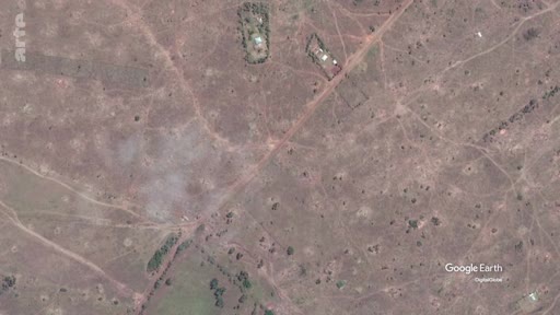 Vue aérienne par satellite montrant une étendue de savane avec des pistes et quelques bâtiments isolés, illustrant les écosystèmes de savane dans le cadre d'un reportage sur le rôle du carbone.