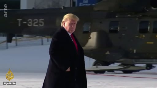 Donald Trump, alors président des États-Unis, est filmé marchant devant un hélicoptère militaire portant l'immatriculation T-325 sur un sol enneigé.