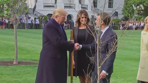Donald Trump, Melania Trump et le président français Emmanuel Macron participent à une cérémonie de plantation d'arbre dans les jardins de la Maison-Blanche à Washington. Cette rencontre diplomatique souligne les relations entre les États-Unis et la France.