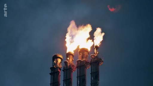 Des cheminées industrielles en activité rejettent des flammes, illustrant les pratiques de torchage dans le secteur pétrolier et gazier. Cette image souligne les enjeux environnementaux liés aux émissions industrielles et au changement climatique.