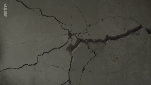 Gros plan sur une fissure importante dans un mur en béton, illustrant les dommages structurels causés par les bombardements à Mykolaïv, en Ukraine.