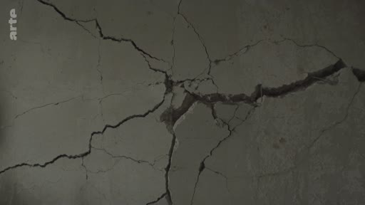 Gros plan sur une fissure importante dans un mur en béton, illustrant les dommages structurels causés par la guerre à Mykolaïv, en Ukraine.