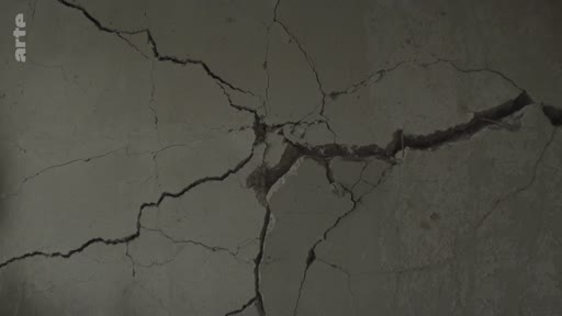 Gros plan sur un mur en béton lourdement fissuré, illustrant les destructions urbaines à Mykolaiv en Ukraine suite aux bombardements. Cette image témoigne de l'impact du conflit sur les infrastructures civiles.