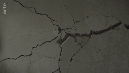 Gros plan sur une fissure importante dans un mur en béton, illustrant les dommages structurels causés par la guerre à Mykolaïv.