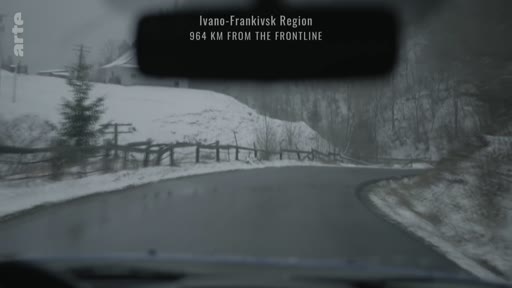 Vue depuis l'intérieur d'un véhicule circulant sur une route enneigée dans la région d'Ivano-Frankivsk, située à 964 km de la ligne de front en Ukraine.