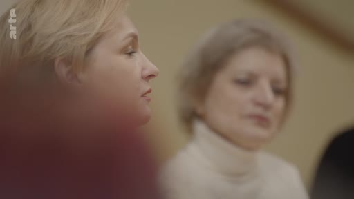 Deux femmes sont filmées en gros plan lors d'une discussion, dans le cadre d'un reportage sur l'éthique du rêve en temps de guerre.