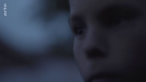 Gros plan sur le visage d'un enfant filmé dans une ambiance sombre et mélancolique, évoquant une réflexion intérieure ou une atmosphère dramatique.