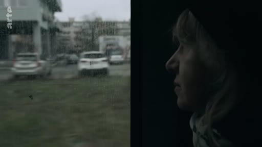 Une femme observe le paysage urbain défiler par la fenêtre d'un véhicule, illustrant son voyage vers une nouvelle vie. La scène capture un moment de réflexion et de transition personnelle.