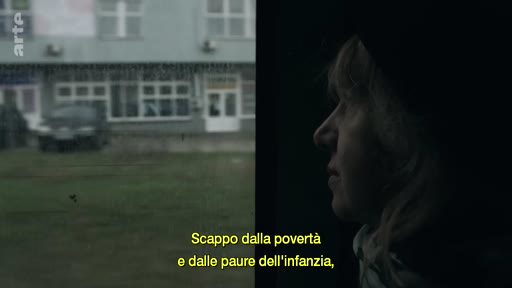 Une femme, vue de profil, regarde par la fenêtre d'un véhicule en mouvement, avec un paysage urbain flou en arrière-plan. Le sous-titre évoque la fuite face à la pauvreté et aux traumatismes de l'enfance.