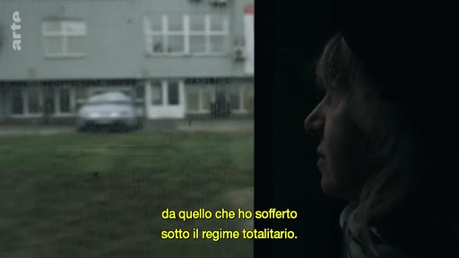Une femme observe le paysage extérieur depuis l'intérieur d'un véhicule, illustrant un témoignage sur la vie sous un régime totalitaire. Le sous-titre évoque la souffrance vécue sous ce type de gouvernement.
