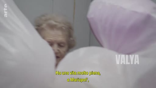 Une femme âgée témoigne de sa vie à Marioupol dans ce reportage. Le sous-titre indique qu'elle a une vie très remplie dans cette ville ukrainienne.