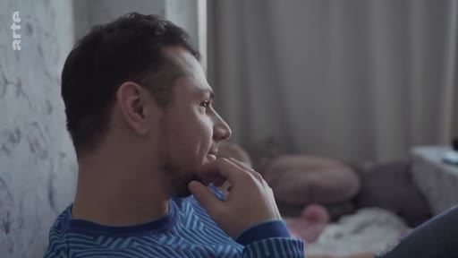 Un homme, filmé en profil, semble préoccupé ou pensif dans un cadre domestique, illustrant une atmosphère d'inquiétude ou de réflexion sur la situation actuelle.