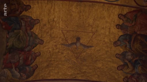 Une fresque murale ancienne représentant la colombe du Saint-Esprit au centre d'un triangle, entourée de plusieurs personnages, probablement les apôtres lors de la Pentecôte. Cette œuvre d'art religieuse est filmée en plan d'ensemble.