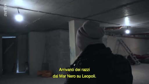 Une personne portant un bonnet se tient dans un abri souterrain sombre à Lviv, en Ukraine, alors que des sous-titres mentionnent des tirs de missiles depuis la mer Noire.