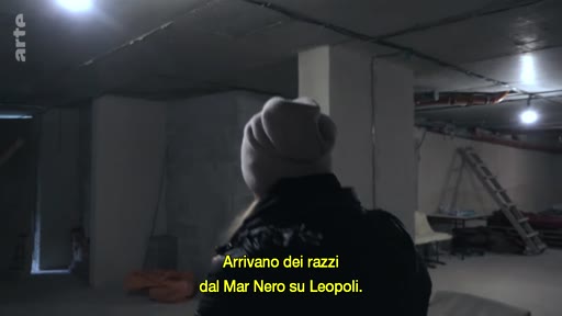 Une personne vue de dos, portant un bonnet, se trouve dans un abri souterrain sombre à Lviv, en Ukraine. Le sous-titre mentionne l'arrivée de missiles depuis la mer Noire vers Lviv.