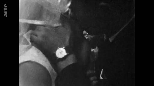 Image d'archive en noir et blanc montrant un gros plan sur le poignet d'une personne portant une montre, évoquant des souvenirs du passé.